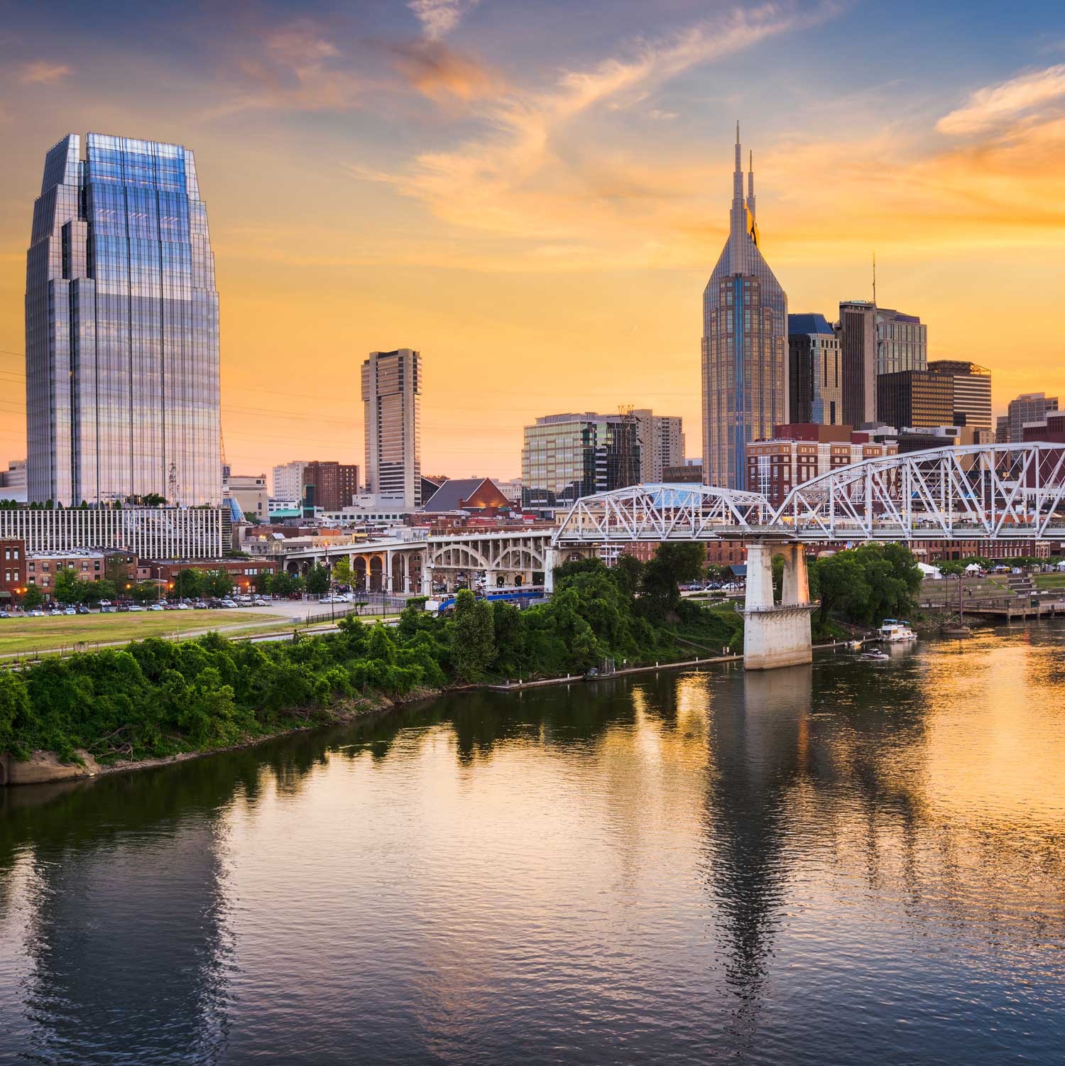 a bridge over a body of water with a city in the background