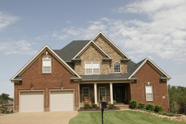 a large brick building with grass in front of a house